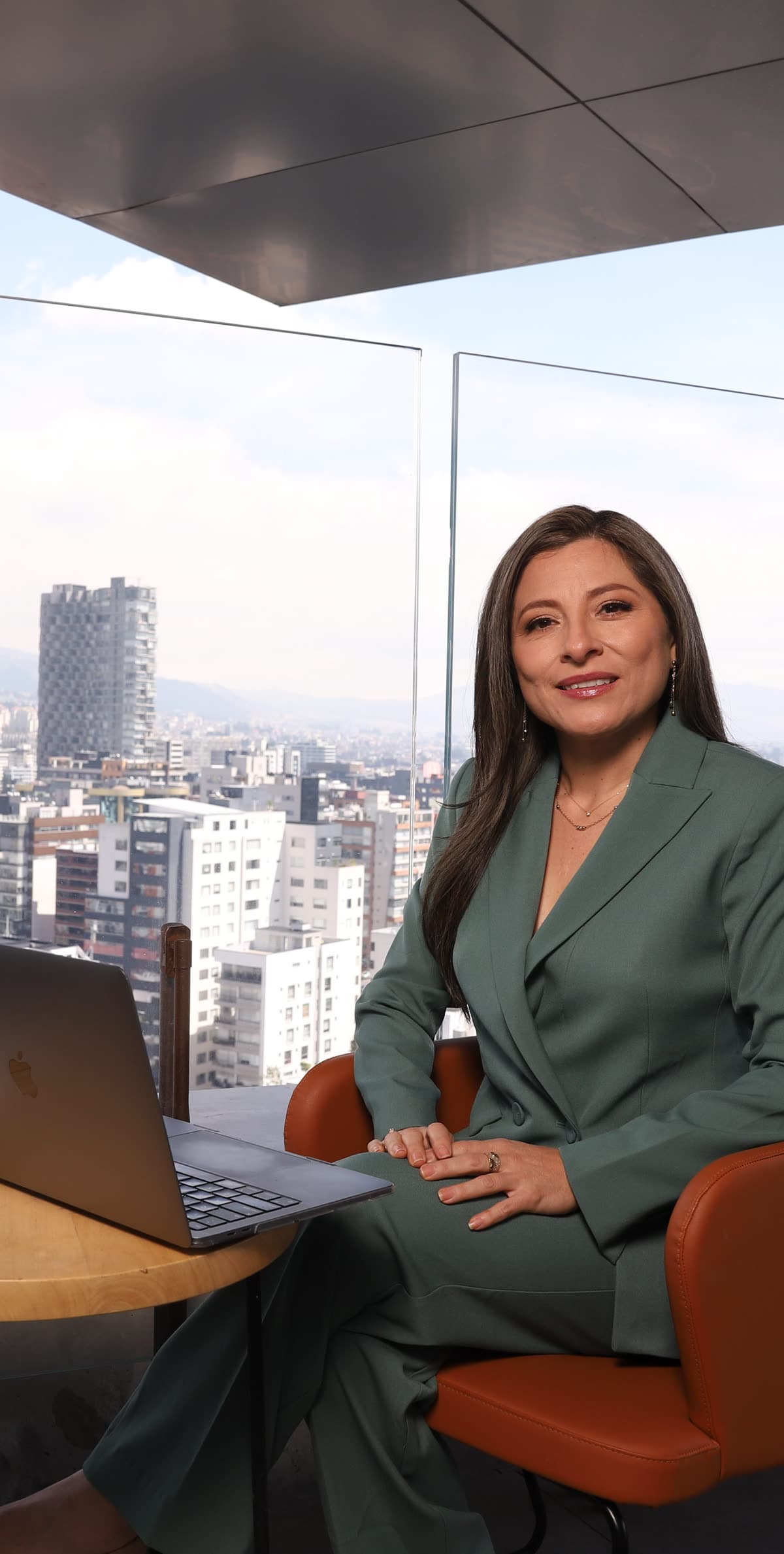 Katherine Gómez trabajando en una terraza sobre la ciudad