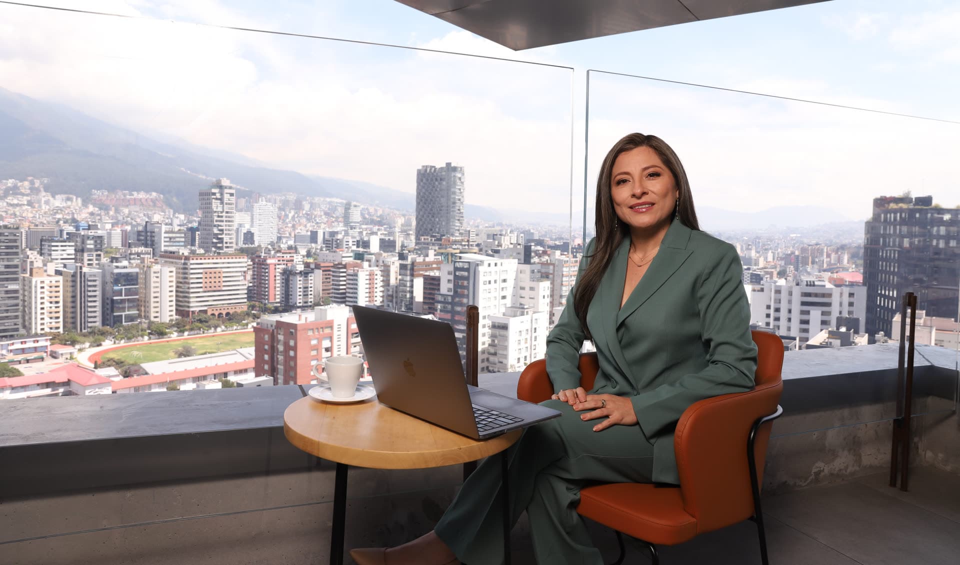 Katherine Gómez trabajando en una terraza sobre la ciudad