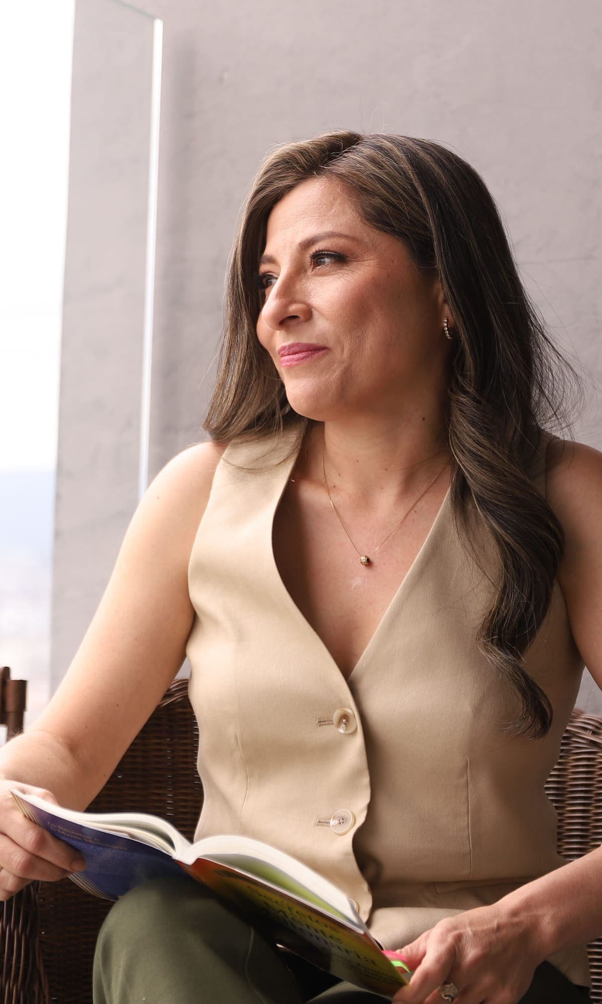 Katherine Gómez junto a la ventana, con un libro en las manos